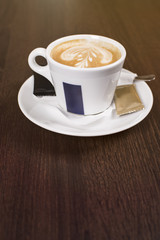 Cup of coffee with beautiful latte art. Tasty cup of coffee on wooden background with beautiful latte art.