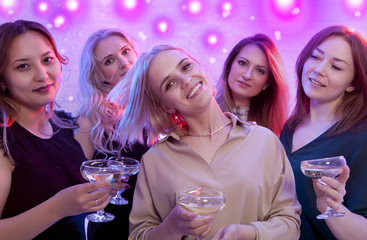Blonde woman looking at camera while dancing at nightclub