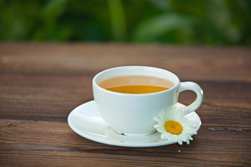 porcelainl cup with green tea on table