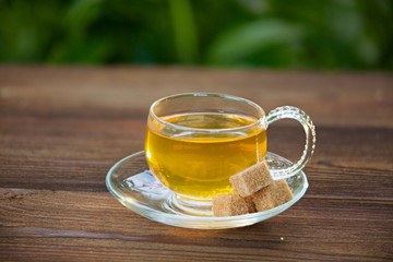 Crystal cup with green tea on table