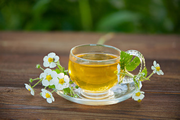 Crystal cup with green tea on table