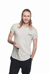 Fototapeta premium young blond man holding keys and looking at camera, isolated on white