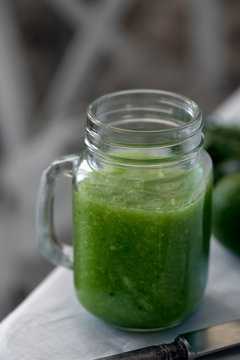 Fresh organic green smoothie with spinach, cucumber on a white tableware. Close up