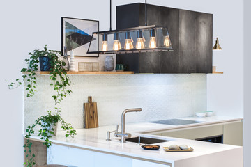 Modern kitchen design in home interior. Facades are painted and made of natural stone. Loft Light Fixture Lights in Black Metal Frame Shade with Clear Panel Glass. Copper Wire. Stone surface.