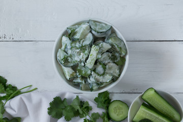 Cucumber salad with yogurt dressing on the white background