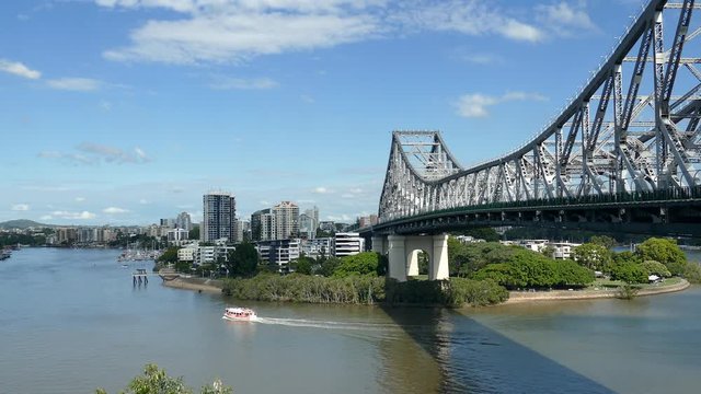 View of the iconic Story Bridge spanning the Brisbane River in Brisbane Queensland Australia with a ferry.