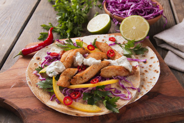 Chicken fajitas vegetables and sauce on a Mexican tortilla tacos