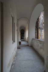 Fototapeta na wymiar Old residential hallway with big arch and painted in white