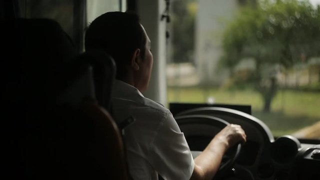 The bus driver is driving along the road.