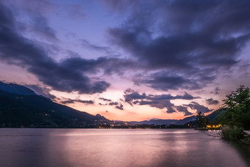 Dramatic sunset cloudscape over mountain lake, cold and warm gradient