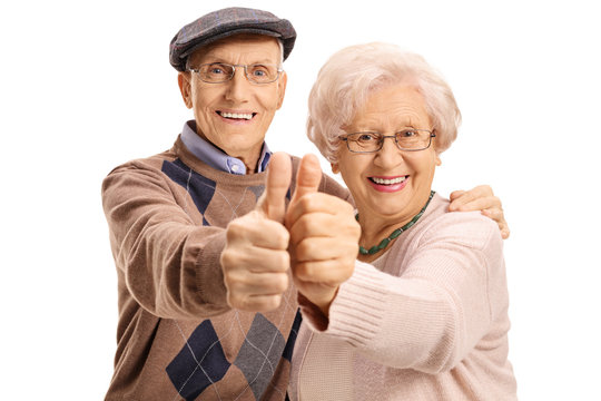 Cheerful mature couple making a thumbs up gesture