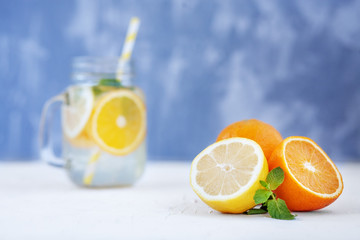 Orange, lemon and mint are on the table. Fruit cocktail. The concept is summer, diet, vegetarian, fitness, healthy eating and lifestyle.
