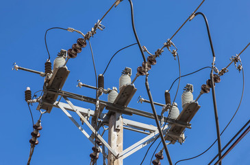 high voltage circuit power line on electricity power pole on blue sky