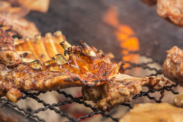 Fototapeta premium Close up barbecue pork ribs roasting on charcoal grill with bright flame Selective focus.