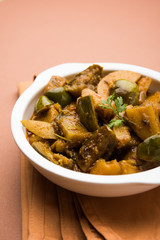 Indian baingan or baigan and aalu sabzi / Aloo Baingan Recipe / indian spicy eggplant and potato curry, served in kadhai or white bowl, selective focus © StockImageFactory