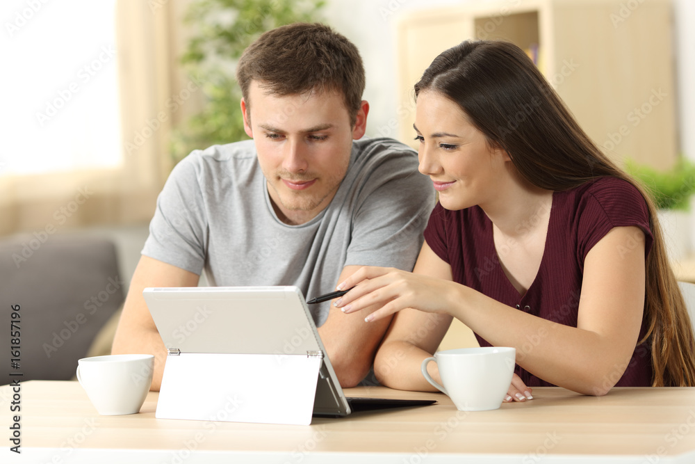 Poster couple searching on line with a tablet pc