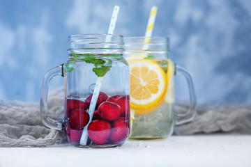 Delicious detox water in a glass jar. Lemon, orange and mint and cherry. The concept is summer, diet, vegetarian, fitness, healthy eating and lifestyle.