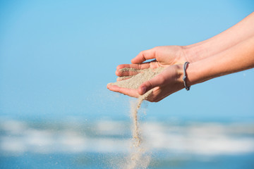 Fototapeta na wymiar Sand slipping through young girl's fingers