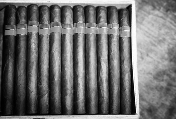 Retro styled photo of large box of Cuban cigars on a wooden table