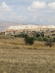 Fototapeta premium Small village and rock formations in Cappadocia's landscape