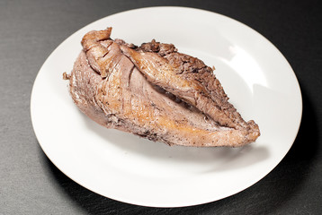 Chicken breast with fried crust on a white plate
