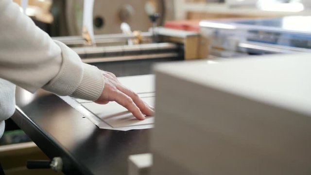 Worker works at polygraph machine, printing industry