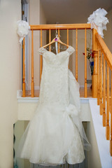 The perfect wedding dress with a full skirt on a hanger in the room