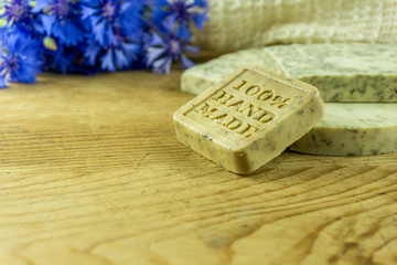 Handmade soap on a rustic wooden board with cornflowers and accessories. - 161869794