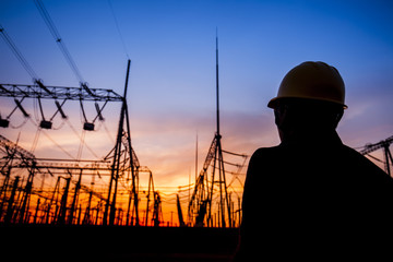 Electricity workers and pylon silhouette