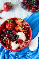Healthy breakfast: cottage cheese with sour cream, strawberry, raspberry, blueberry, cherry and red currant on blue wooden table. Selective focus
