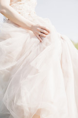 Hands of bride on wedding dress on sunny day. fine art photography.