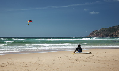 Obraz premium Surfer sitting on the beach
