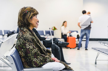 Woman waiting seated on the airport's departure lounge