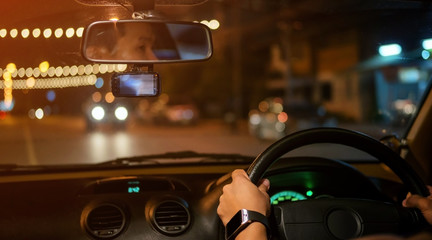 Men driving a car at night.