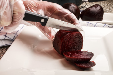 senior female chef cutting beetroot