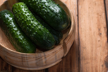 Whole cucumbers in wooden utensils,