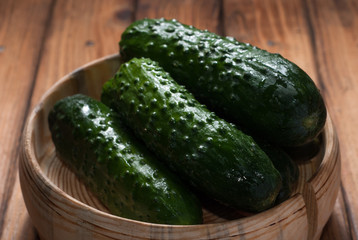 Whole cucumbers in wooden utensils,