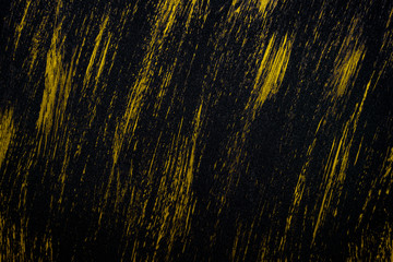 Black metal textured background with smears of yellow paint