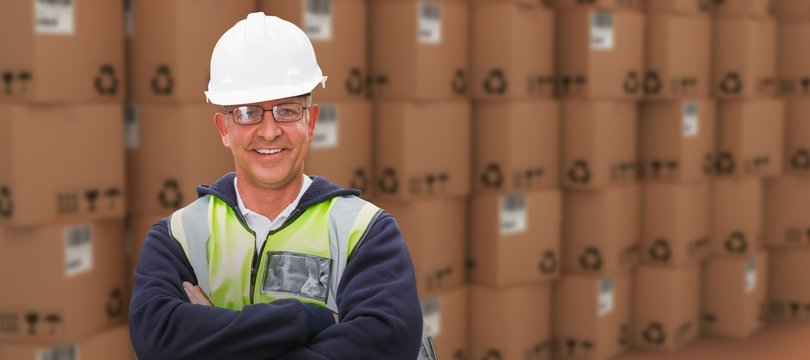 Composite image of worker wearing hard hat in warehouse