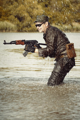 Naklejka premium Action soldier in uniform attacking with assault rifle