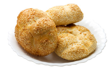 Buns with sesame on a white plate on a white background isolated
