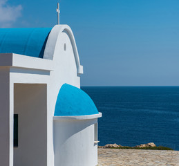 Traditional white chapel with a blue roof on the seaside. Agioi Anargyroi, Cyprus