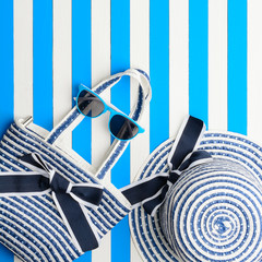 Beach accessories on a blue and white background. Top view, flat lay.