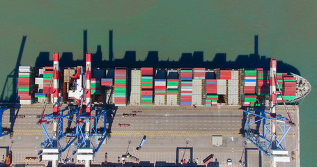 Commercial port with container ships - Top down aerial view.