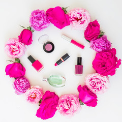 Obraz na płótnie Canvas Beauty blogger desk with cosmetics - lipstick, eye shadows, nail polish and pink frame of roses on white background. Flat lay, top view.