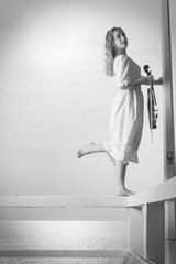 Woman on pier outside holding violin
