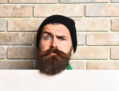 Bearded brutal caucasian hipster with white paper sheet