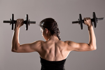 Fototapeta na wymiar girl in sexy black dress lifting weights