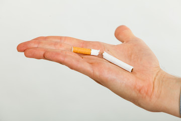 Closeup of broken cigarette on male hand.