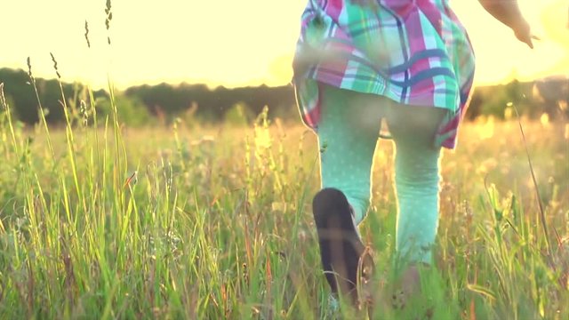 Happy little girl enjoying nature on summer meadow, running and laughing. Slow motion. 4K UHD video 3840X2160